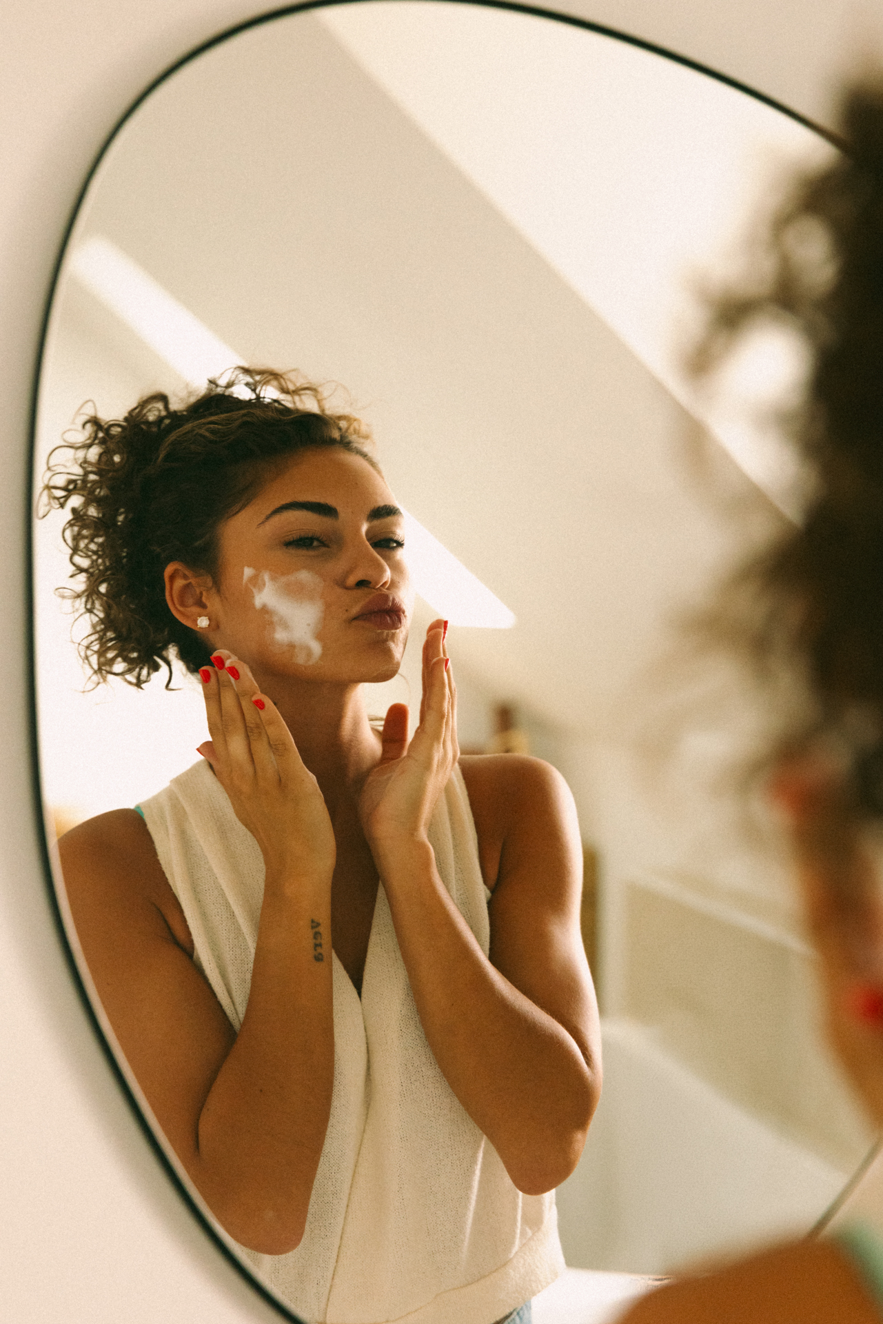 Vrouw brengt Skin Architect crème aan voor de spiegel